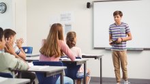 A photo of a high school student presenting a short speech in front of his classmates