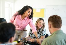 A photo of a teacher guiding students through a group activity.