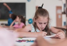 Elementary student writing at her desk