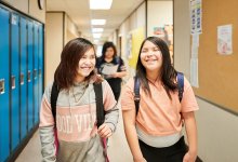 A photo of elementary students walking through a school hallway.