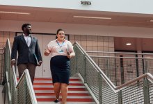 A photo of two administrators having a conversation while walking through a school.