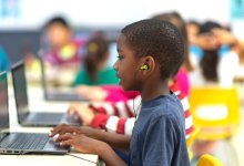 A photo of an elementary student watching a video on a laptop during a blended learning writing workshop.