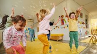Preschool students jumping around with bubbles