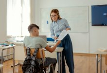 A photo of a teacher handing feedback to a student.