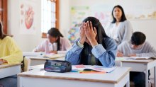 photo of a student who appears stressed out in a classroom