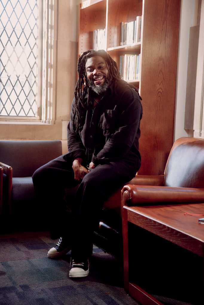 Jason Reynolds sits in a school library