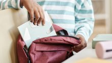 middle school student independently packing a backpack