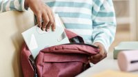 middle school student independently packing a backpack