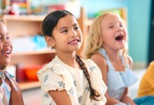 Elementary students sitting together on the classroom floor
