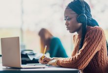 High school student working on a laptop and listening to music