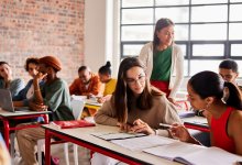 High school teacher observing students working in small groups