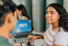 Two students working together with a laptop