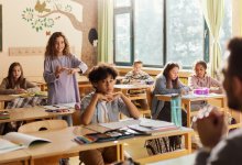 A photo of a middle school student standing up to ask a question during class