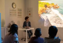 A photo of a teacher showing her students a video