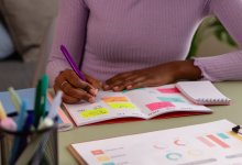 Student making notes on sticky notes in a planner