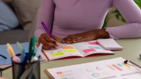 Student making notes on sticky notes in a planner