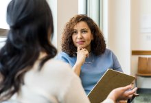 A photo of an administrator listening carefully to a high school student