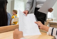 A photo of a teacher handing out a test to her students