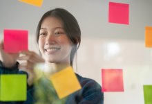 High school student writing a question on a sticky note