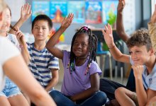 Elementary students raising their hands