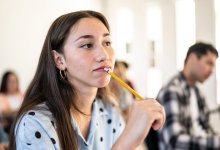 High school student thinking about writing in class