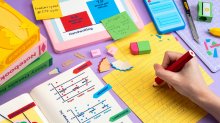 image of someone taking notes on a desk with all objects made from paper.