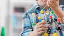 Student creating science project with gumdrops and toothpicks