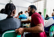Teacher kneeling down and talking to a student