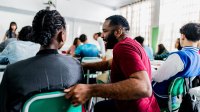 Teacher kneeling down and talking to a student