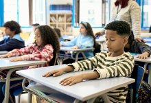 Elementary students taking deep breaths in class, practicing an SEL strategy they've learned for the end of the school year