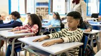 Elementary students taking deep breaths in class, practicing an SEL strategy they've learned for the end of the school year