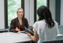 A photo of a teacher and administrator and teacher examining data during a one on one meeting