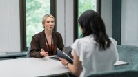 A photo of a teacher and administrator and teacher examining data during a one on one meeting
