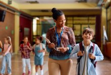 Principal talking with a student in school hallway