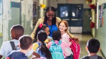 Principal greeting elementary school students