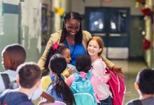 Principal greeting elementary school students