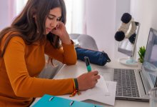 A photo of a high school student highlighting at her desk at home