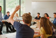 A photo of a high school student raising his hand during math class