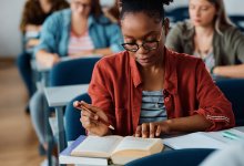 High school students reading books for research purposes