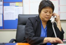 A photo of an administrator dialing a number to call a teacher for a short meeting