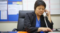 A photo of an administrator dialing a number to call a teacher for a short meeting