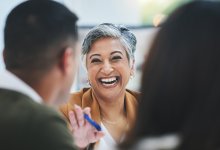 A school leader warmly talking to teachers during a meeting