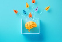 Multicolored paper planes flying from a brain in a small enclosure