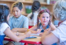 Elementary teacher working with student on writing skills