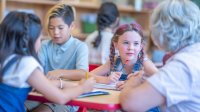 Elementary teacher working with student on writing skills
