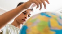 A middle school student observing a globe