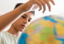 A middle school student observing a globe