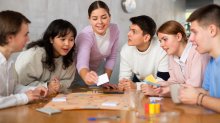 A group of high school students playing a student-made board game