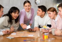A group of high school students playing a student-made board game