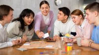 A group of high school students playing a student-made board game